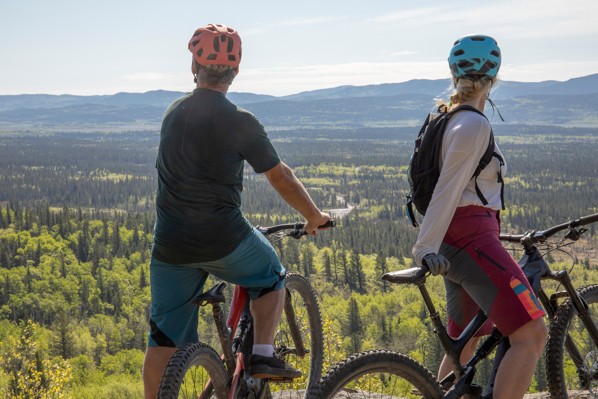 Couple on mountain e-bikes relax on mountain ridge